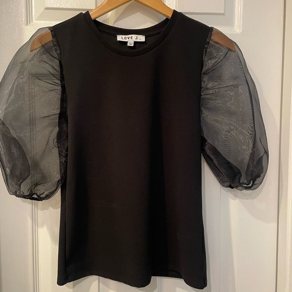 Black top featuring sheer puff sleeves